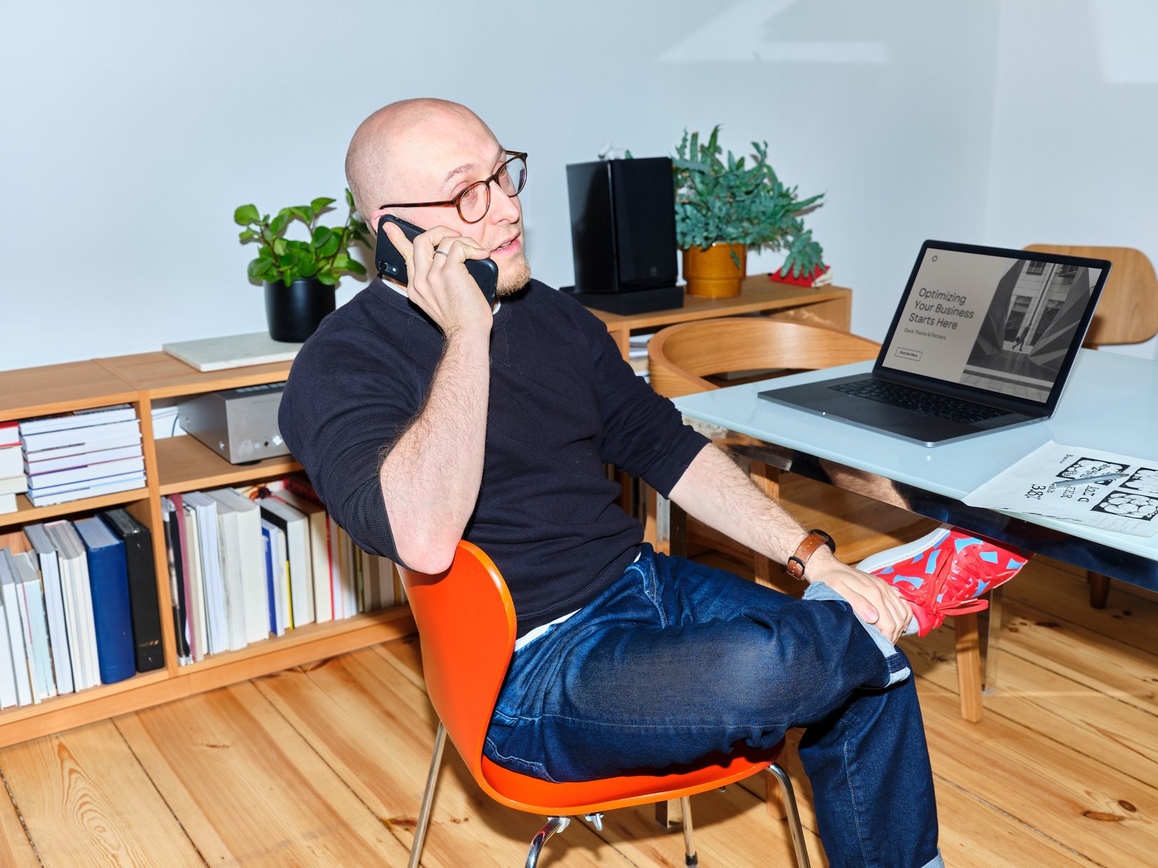 Male Graphic Designer Taking a Call in Home Office